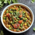 a bowl of soup with vegetables and herbs