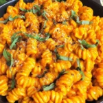 Creamy Gochujang Pasta with fresh basil and a sprinkle of pepper, a spicy and savory dish that's perfect for dinner.