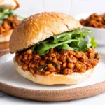 Lentil Sloppy Joes sandwich served on a toasted bun with fresh greens
