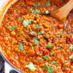 Vegan Lentil Chili Recipe simmering in a pot with tender lentils, tomatoes, and fresh cilantro