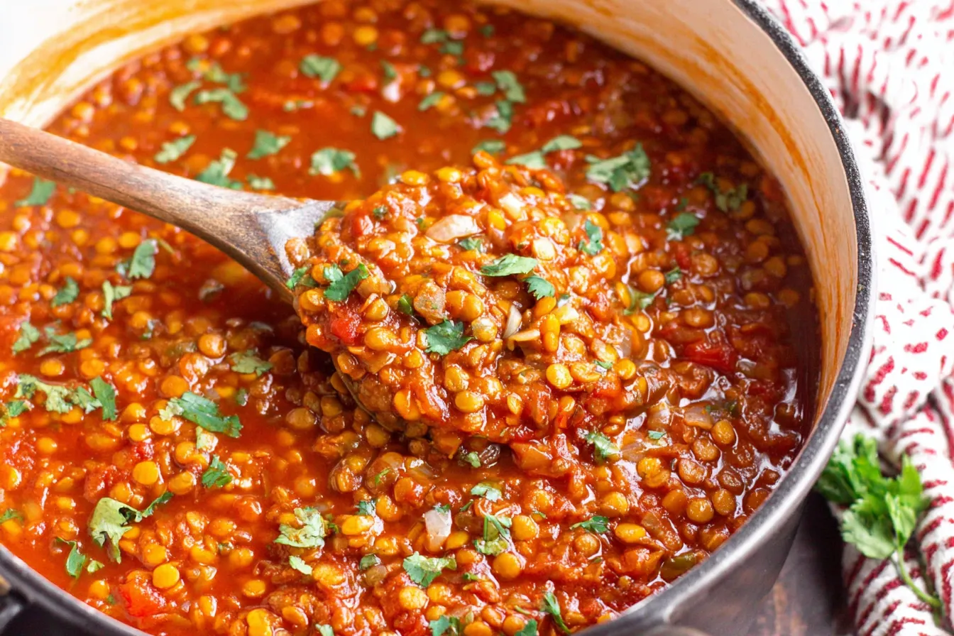 Vegan Lentil Chili Recipe served warm with a spoon, showing rich texture and bold spices