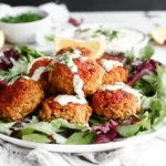 Vegetarian Lentil Meatballs on fresh greens with creamy sauce