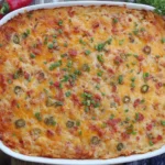 Baked Pimento Cheese Hash Brown Casserole in a white dish, topped with melted cheese, jalapeños, and green onions.
