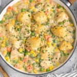 Crustless Chicken Pot Pie in a skillet with creamy chicken, peas, corn, carrots, and a peppery herb finish.