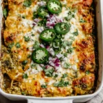 Healthy Salsa Verde Chicken Casserole baked in a white dish with melted cheese, sliced jalapeños, red onion, and fresh cilantro