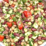 Mediterranean Bean Salad with chickpeas, kidney beans, cucumbers, tomatoes, red onion, and fresh herbs in a bowl