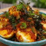 Spicy Gochujang Eggs coated in rich Korean chili sauce with scallions and seaweed