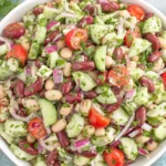 Mediterranean Bean Salad Recipe served in a bowl with mixed beans, cucumbers, tomatoes, red onion, and herbs
