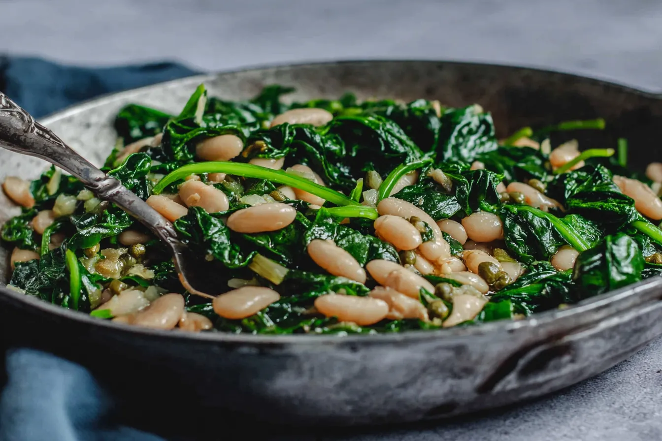 Sautéed Garlic Spinach and White Beans cooked in a skillet with olive oil and fresh greens