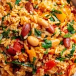 Healthy Mediterranean Rice and Beans in a bowl with fluffy rice, mixed beans, tomatoes, peppers, spinach, and fresh herbs.