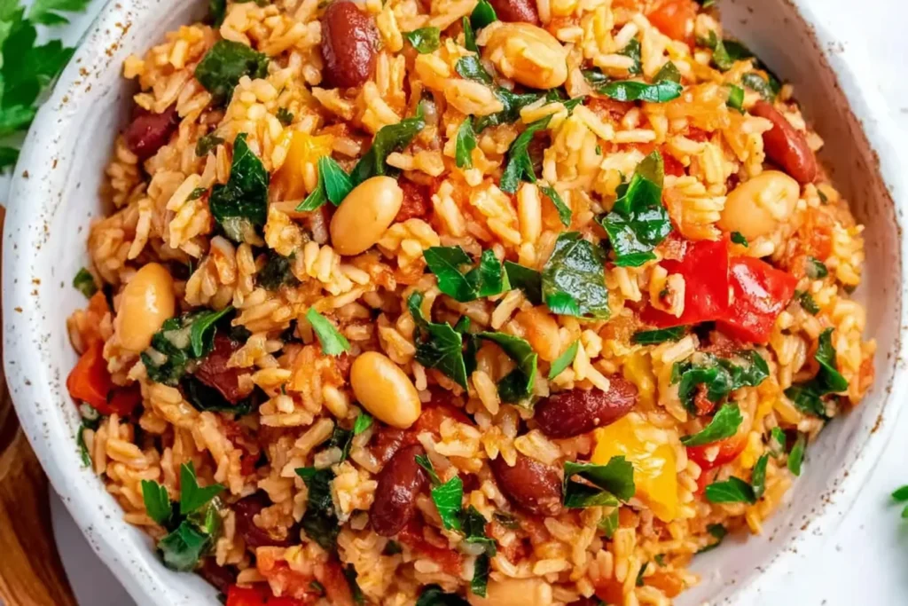 Healthy Mediterranean Rice and Beans topped with fresh parsley, featuring seasoned rice, mixed beans, tomatoes, peppers, and leafy greens.