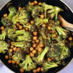 Garlic Broccoli Stir Fry With Chickpeas in a skillet, featuring tender broccoli florets and saucy chickpeas ready to serve.