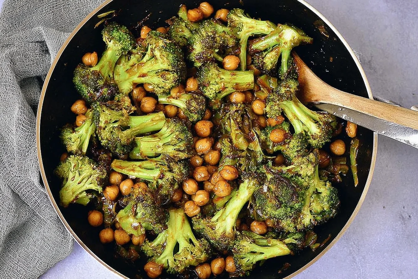 Garlic Broccoli Stir Fry With Chickpeas in a skillet, featuring tender broccoli florets and saucy chickpeas ready to serve.