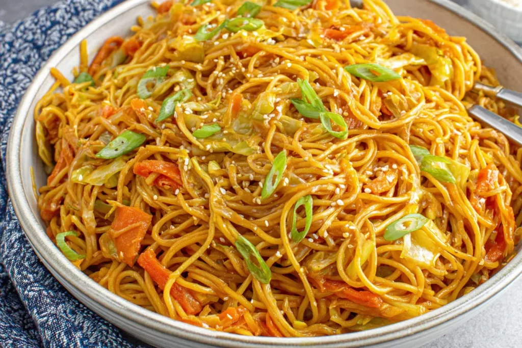 Easy One-Pot Teriyaki Noodles Recipe plated with cabbage, carrots, sesame seeds, and green onions