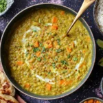 Green Lentil Dal Recipe served in a bowl with naan bread, basmati rice, lime wedges, and fresh cilantro garnish
