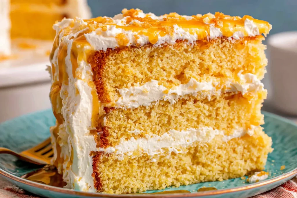 Layered Cornbread Cake with Whipped Honey Butter Frosting served on a plate with thick creamy layers and honey topping
