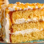 Layered Cornbread Cake with Whipped Honey Butter Frosting served on a plate with thick creamy layers and honey topping