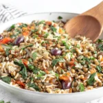 Mediterranean rice and lentils recipe in a large skillet with spinach, bell peppers, olives, and fluffy rice
