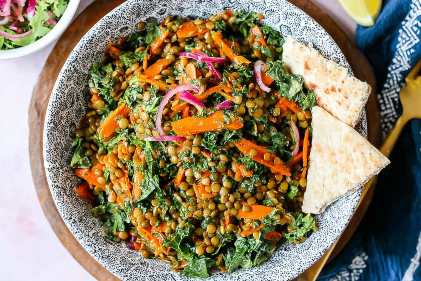 Moroccan Lentil Carrot Salad in a patterned bowl with kale, red onion, and pita wedges, tossed in a lemony spiced dressing.