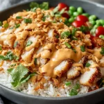 Chicken Crispy Rice Salad with Creamy Peanut Dressing served with sliced crispy chicken, fluffy rice, fresh herbs, edamame, and creamy peanut sauce