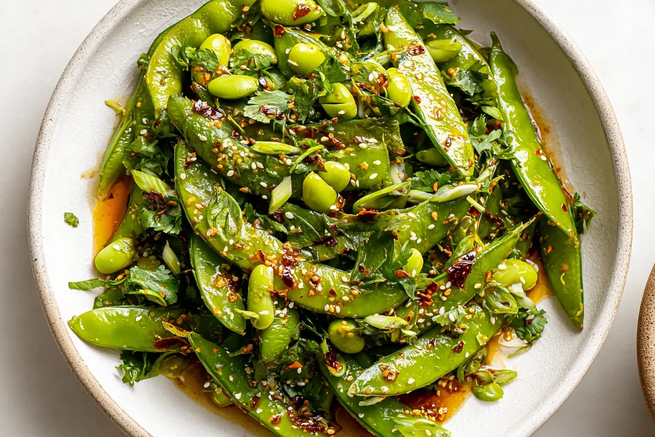 Fresh Chili Crisp Snap Pea Salad with edamame, cilantro, and toasted sesame seeds in spicy dressing