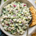 Tzatziki Chicken Salad with Greek yogurt, cucumber, dill, red onion, and feta served in a bowl with crackers