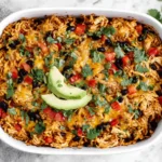 Easy Chicken Burrito Casserole served in a white baking dish topped with avocado slices, cilantro, rice, chicken and melted cheese