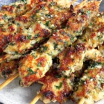 Garlic Parmesan Chicken Skewers served on a plate with crispy edges, garlic butter sauce, parmesan cheese, and parsley