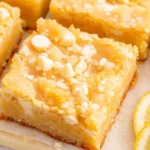 Stacked Lemon Gooey Bars with lemon slices and white chocolate chips
