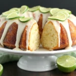 Lime Bundt Cake with creamy lime glaze and fresh lime slices, soft buttery texture shown in center cut
