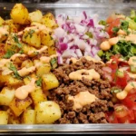 Loaded Potato Taco Bowl Meal Prep with crispy potatoes, taco beef, fresh salsa, and sriracha drizzle