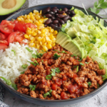 Colorful Taco Lunch Bowls with turkey meat, rice, corn, beans, avocado, and lettuce