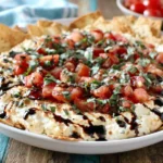 Bruschetta Dip served with crackers, topped with tomatoes, basil, and balsamic glaze