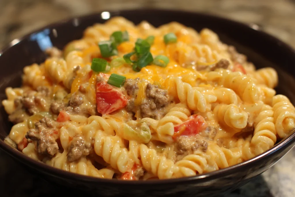 Close-up of Creamy Rotel Pasta with Ground Beef served in a bowl with cheesy sauce and diced tomatoes