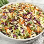 Colorful Crunchy Detox Salad with raisins, almonds, and fresh parsley in a large serving bowl