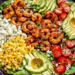 Honey Lime Shrimp Salad platter with avocado halves, corn, cherry tomatoes, and fresh greens