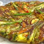Homemade Korean Vegetable Pancakes (Yachaejeon) sliced and garnished with sesame seeds and green onions