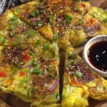 Korean Vegetable Pancakes (Yachaejeon) served with soy dipping sauce on wooden board