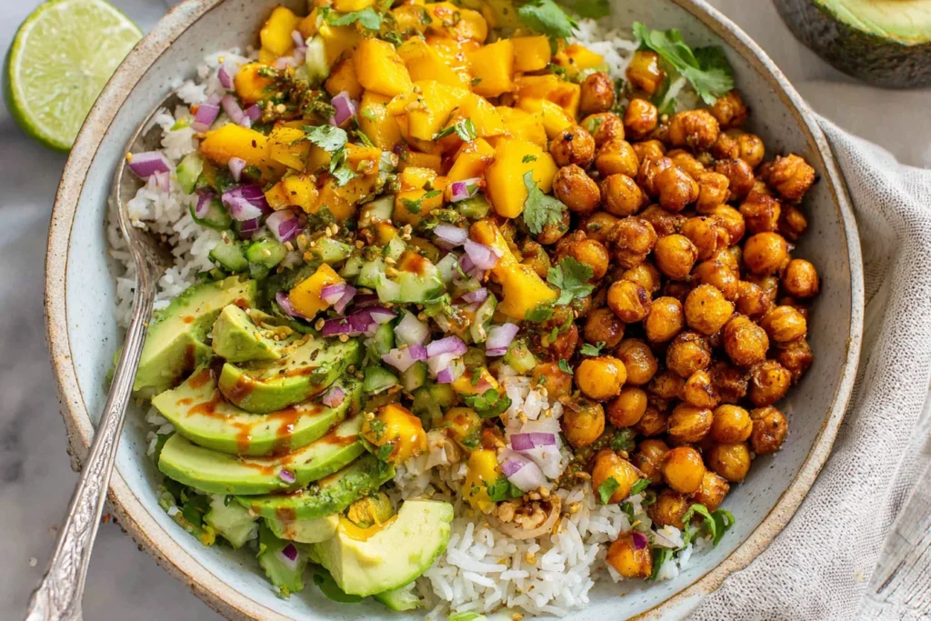 Mango Chickpea Salad with rice, avocado slices, cucumber, and tangy dressing