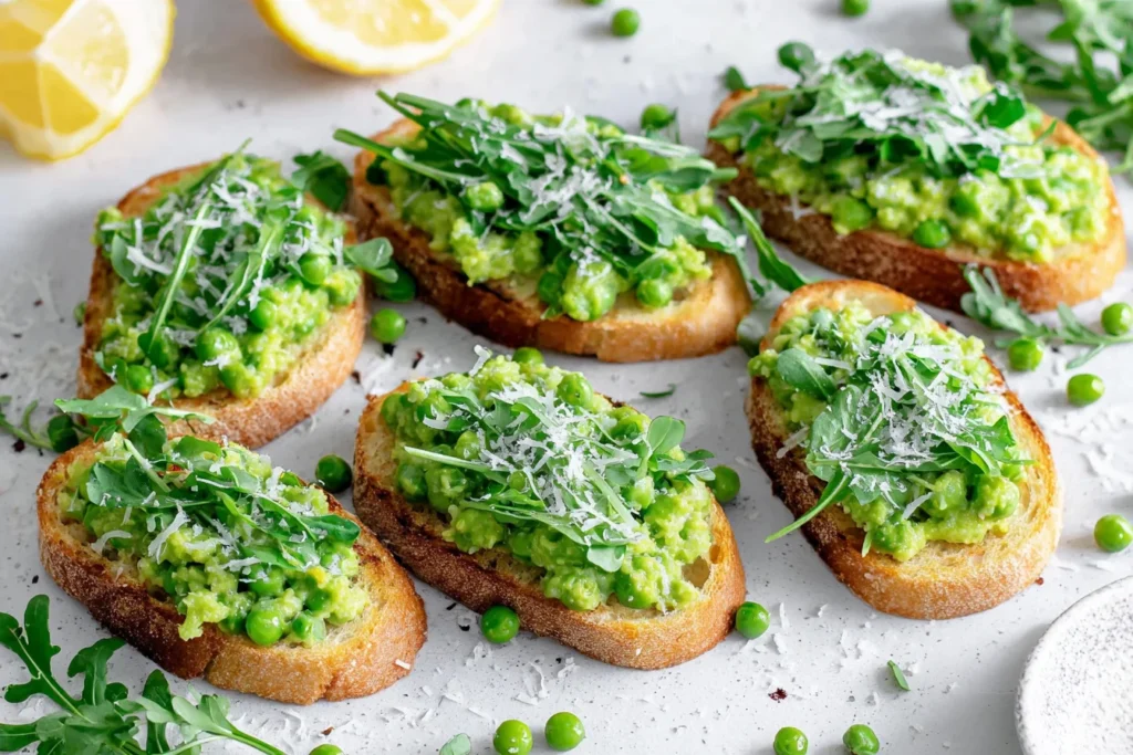 Pea Bruschetta Recipe (Pea Crostini) served on toasted ciabatta with whole peas parmesan and arugula