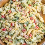 Creamy Ranch Pasta Salad with rotini, fresh vegetables, and herbs in a wooden bowl