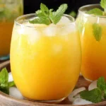 Refreshing Homemade Mango Lemonade in round glasses with mint garnish and ice