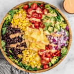 Southwest Salad with black beans, corn, avocado, tomatoes, and chipotle dressing in a wooden bowl
