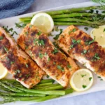 Air Fryer Salmon served with roasted asparagus, lemon slices, and fresh parsley