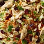 Asian Chicken Cranberry Salad topped with cranberries, almonds, green onions, and shredded chicken