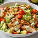 Avocado Chicken Salad Recipe topped with grilled chicken, avocado cubes, cherry tomatoes, and creamy herb dressing