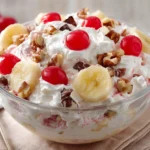 Banana Split Fluff Salad Recipe served with cherries, bananas, whipped topping, and walnuts in a glass dessert bowl