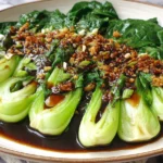 Easy Bok Choy With Garlic Soy Sauce arranged on a serving plate with glossy garlic sauce and vibrant green bok choy