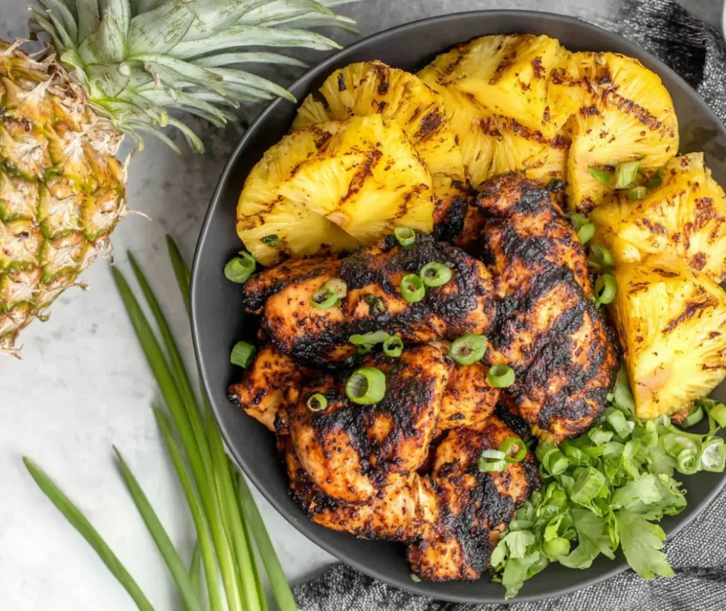 Easy Homemade Grilled Pineapple Chicken with grilled pineapple rings and fresh herbs in a bowl