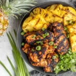 Easy Homemade Grilled Pineapple Chicken with grilled pineapple rings and fresh herbs in a bowl
